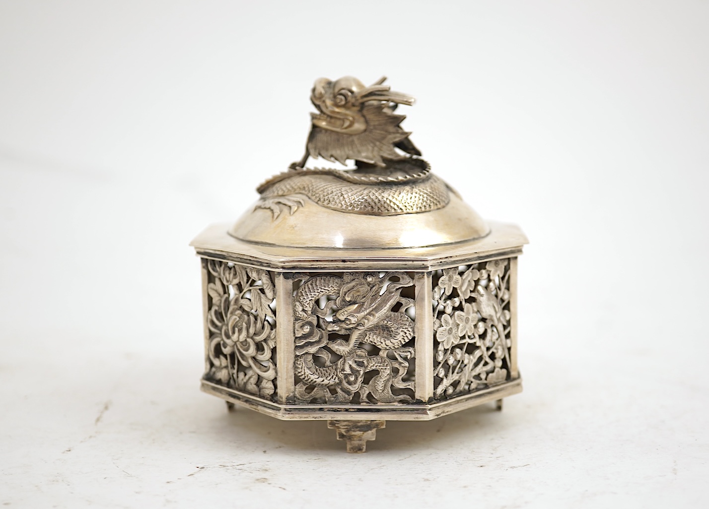 A late 19th century Chinese Export pierced silver card case, maker KMS(Kwong Man Shing), decorated with dragons amid clouds, 10.4cm, together with a Chinese Export pierced silver octagonal box and cover, by Luen Wo?, cir